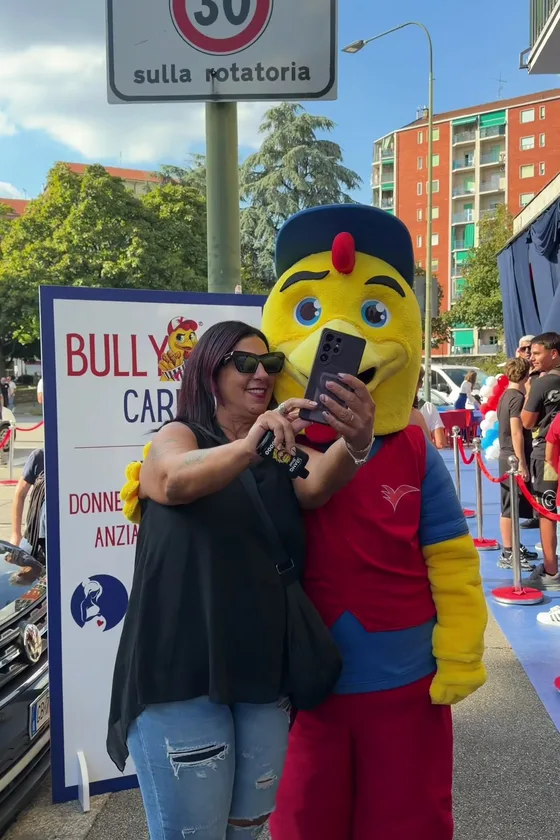 A guest takes a selfie with the Bully Chicken mascot